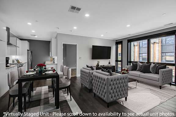 a living room with grey and white furniture and a table with chairs at Nineteen North Apartments , Buffalo, NY