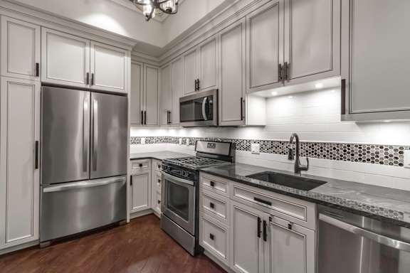 A modern kitchen with stainless steel appliances and white cabinets.