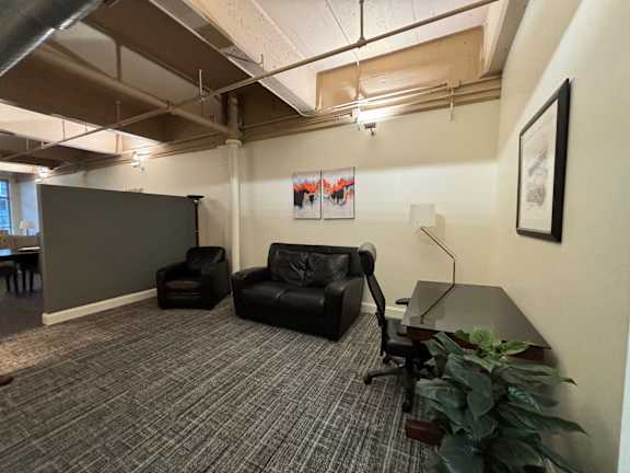 a room with a leather chair and a desk and a table