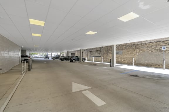 a parking garage with cars and a brick wall at Nineteen North, Buffalo, 14202