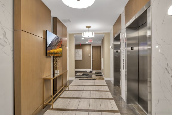 a long hallway with elevators and a painting on the wall at Nineteen North, New York