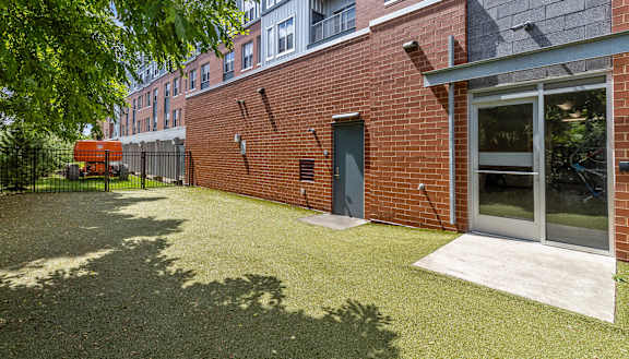 the yard of a brick apartment building with grass and a backdoor Hot Metal Flats apartments, Southside Pittsburgh, PA