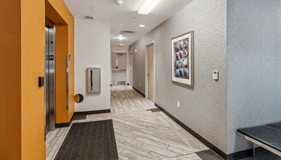 a hallway with doors and a painting on the wall and a door to a room Hot Metal Flats apartments, Southside Pittsburgh, PA