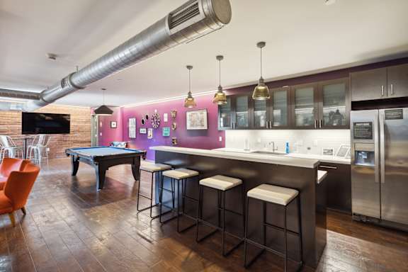 A modern kitchen with a pool table and bar stools.at Walnut on Highland, Pennsylvania 15206