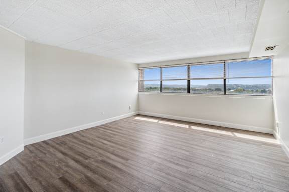 A room with a large window and wooden flooring at Walnut Towers at Frick Park, Pennsylvania