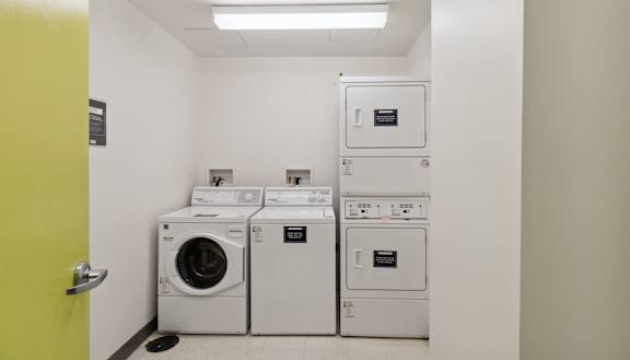 a washer and dryer room with a row of washing machines