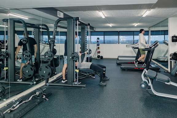 A gym with people working out and a man on a treadmill at Walnut Towers at Frick Park, Pittsburgh, PA