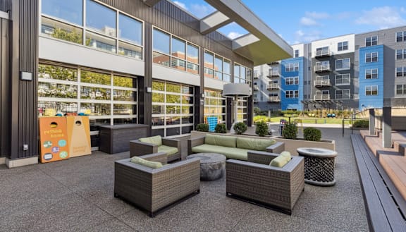 an outdoor patio with couches and tables in front of a building at Bakery Living in Pittsburgh, PA 15206