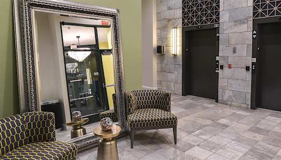 a lobby with chairs and a large mirror at Walnut on Highland, Pennsylvania 15206