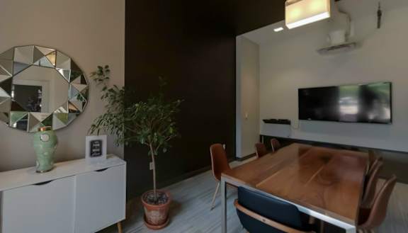 a dining room with a wooden table and chairs and a flat screen tv on the wall at Bakery Living, Shadyside, Pittsburgh, PA 15206