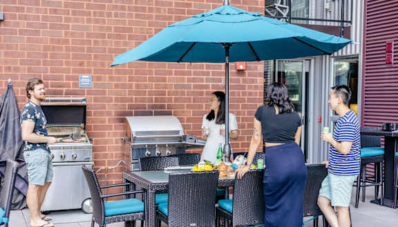 a group of people standing around a table under an umbrella at Walnut on Highland, Pennsylvania 15206