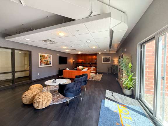 Lounge room with a blue rug and a yellow line on it. Hot Metal Flats apartments, Southside Pittsburgh, PA
