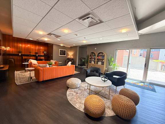 Lounge room with a sofa, chairs, and a coffee table. Hot Metal Flats apartments, Southside Pittsburgh, PA