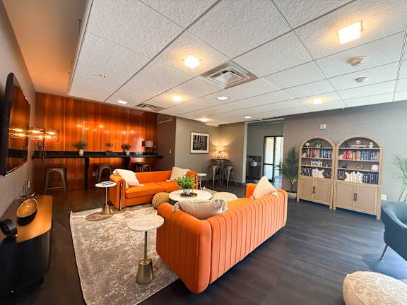 Lounge room with a sofa, a table, and a bookshelf. Hot Metal Flats apartments, Southside Pittsburgh, PA