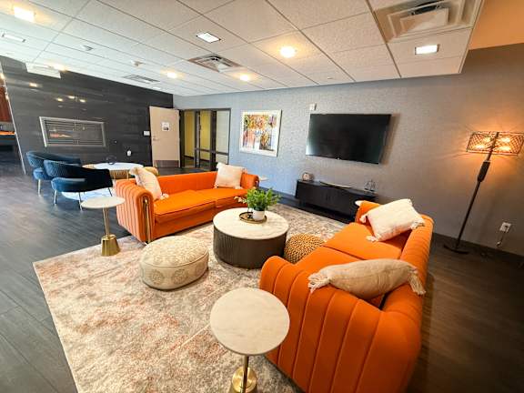 Lounge room with a fireplace and a television. Hot Metal Flats apartments, Southside Pittsburgh, PA