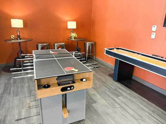 A ping pong table is in the middle of a room with orange walls. Hot Metal Flats apartments, Southside Pittsburgh, PA