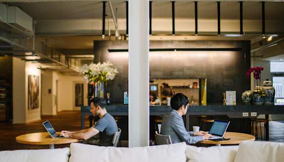 two men sitting at tables working on their laptops in a large open space at Bakery Living, Shadyside, Pittsburgh, PA 15206