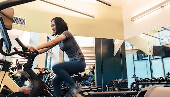 a woman riding an exercise bike in a gym