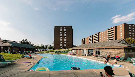 a large swimming pool with people in it and a building in the background at Walnut Crossings, Monroeville, PA, 15146