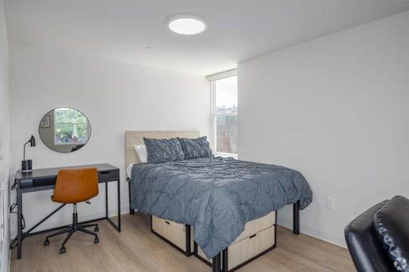 A bedroom with a bed, desk, and chair.