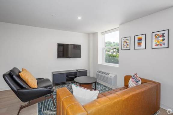 A living room with a black leather chair and a brown sofa.