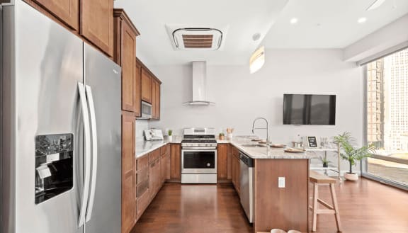 a kitchen with wooden cabinets and a stainless steel refrigerator at The Washington at Chatham, Pittsburgh, PA 15219