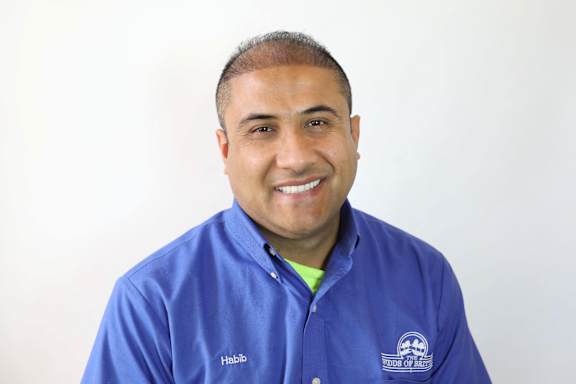 A man wearing a blue shirt with the word "Habib" on it.