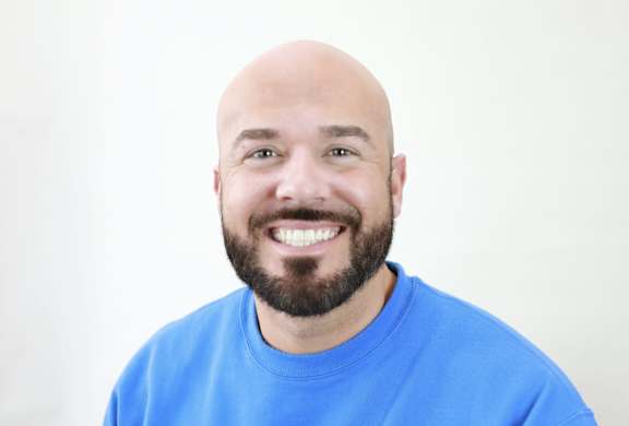 A man with a beard is wearing a blue shirt.