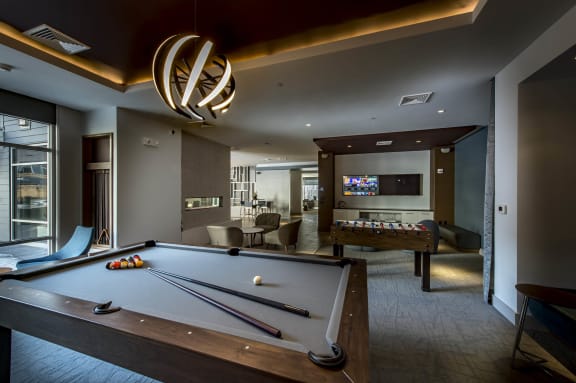 a pool table and a foosball table in a room with a television