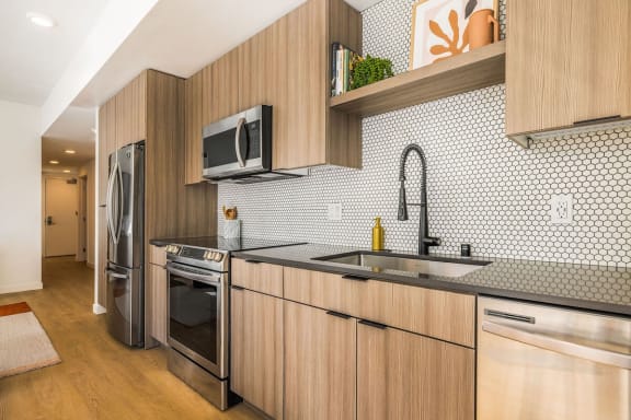 apartment kitchen with tile backsplash and black countertops