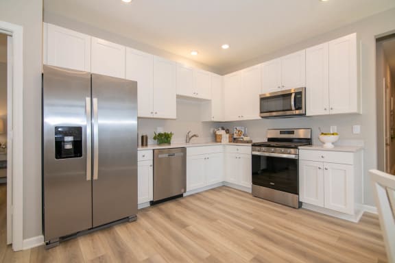 a kitchen with stainless steel appliances and white cabinets  at Jackson Run Townhomes, Indiana, 46075