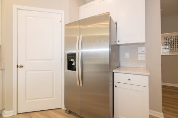 a stainless steel refrigerator in a kitchen with white cabinets at Jackson Run Townhomes, Indiana, 46075
