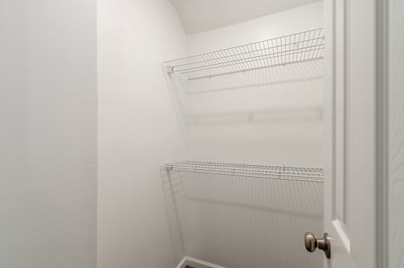 Empty white shelves in a white door.