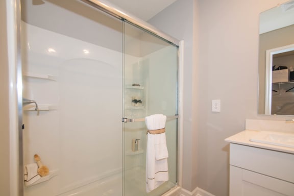 a white bathroom with a shower and a sink at Jackson Run Townhomes, Indiana