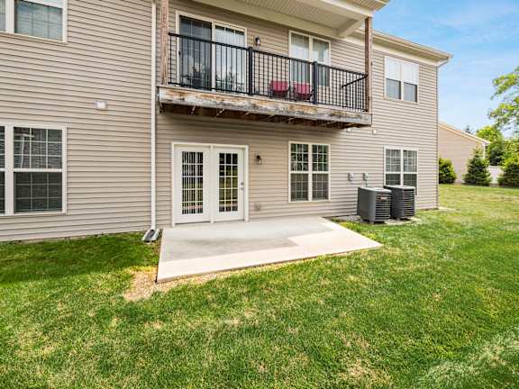A two-story apartment building with a balcony and a driveway. at River View at Bexley Apartments, River View at Bexley, OH