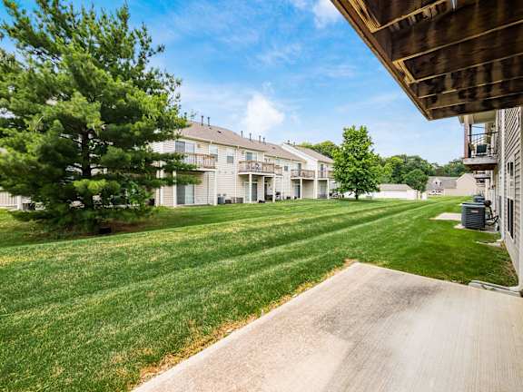 A residential area with apartment buildings and a well-maintained lawn. at River View at Bexley Apartments, River View at Bexley 43209