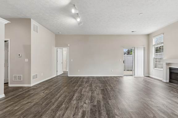 A spacious living room with wood flooring and a fireplace.