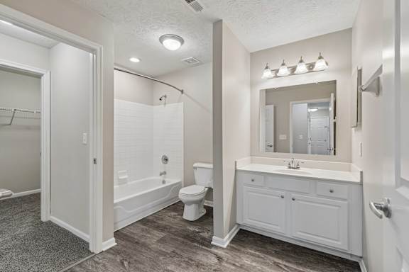 A white bathroom with a toilet, sink, and mirror.