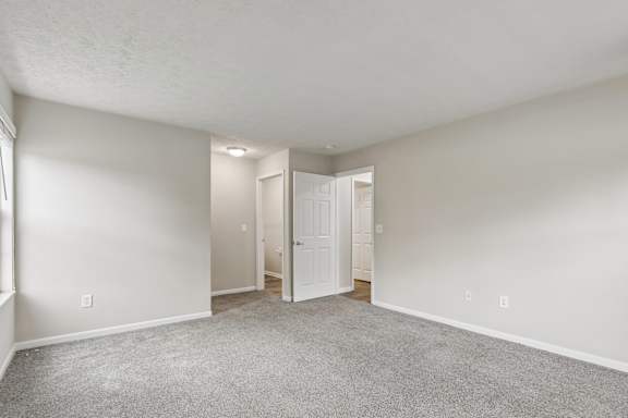 A room with white walls and carpeted floor.