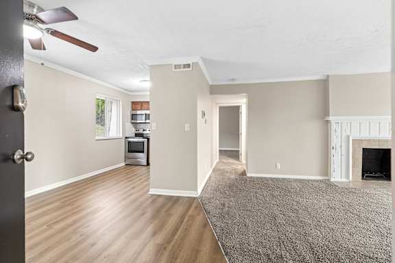 A room with a fireplace and a rug on the floor.