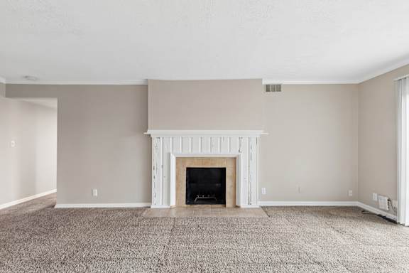 A living room with a fireplace and carpeted floor.