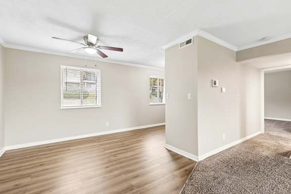 A room with a ceiling fan and a window with blinds.