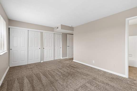 A room with a carpeted floor and white walls.