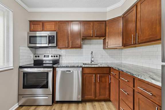 A kitchen with wooden cabinets and stainless steel appliances.