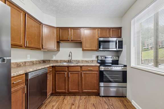 A kitchen with wooden cabinets and stainless steel appliances.