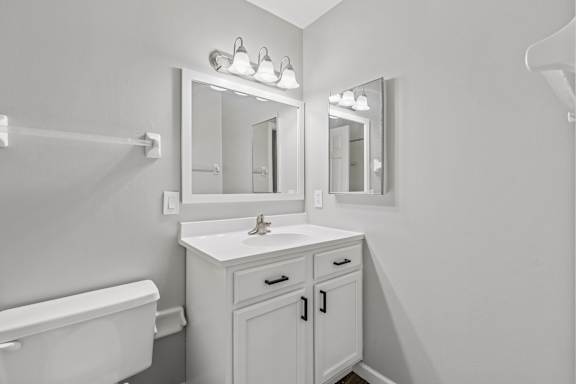 A white bathroom with a sink, mirror, and bathtub.