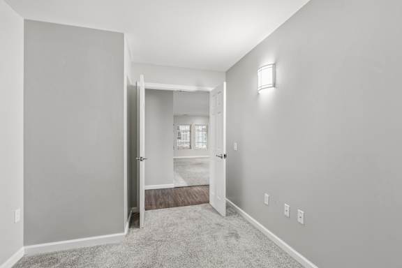 A room with a carpeted floor and a white door.
