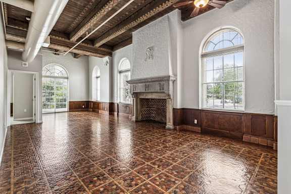 A large room with a fireplace and a tiled floor.