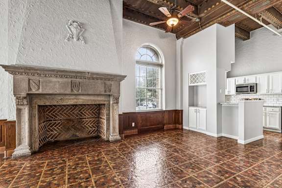 A large room with a fireplace and a tiled floor.