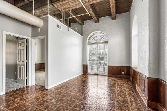 A room with a tiled floor and a large arched window.